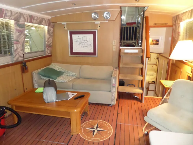 Slide: The Image of 1978 Bertram 42 Flybridge Motor Yacht interior with cozy seating, wooden flooring, and nautical decor. - 11