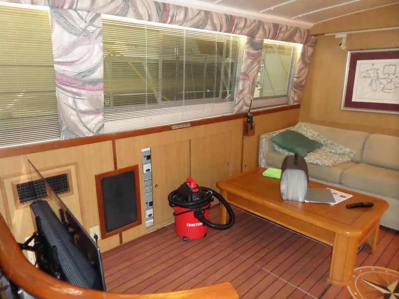 Slide: The Image of 1978 Bertram 42 Flybridge Motor Yacht interior with sofa, table, and vacuum cleaner. - 12