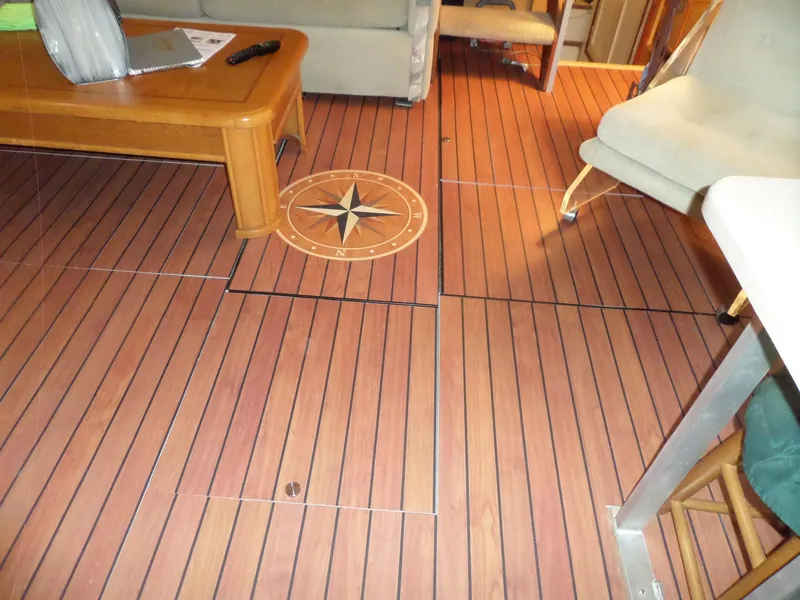Slide: The Image of 1978 Bertram 42 Flybridge Motor Yacht interior with wooden flooring and compass design. - 13