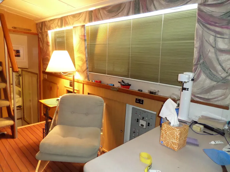 Slide: The Image of Interior of a 1978 Bertram 42 Flybridge Motor Yacht with cozy seating and wooden accents. - 14