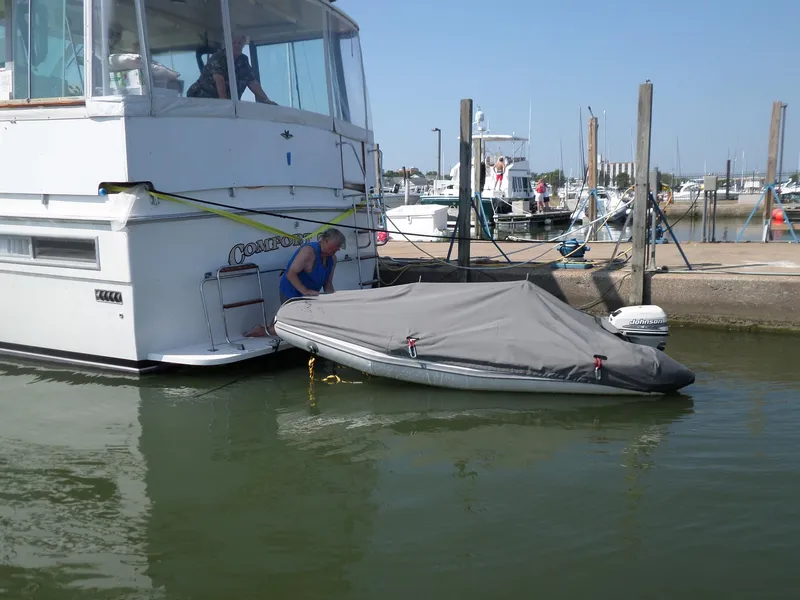 Slide: The Image of 1978 Bertram 42 Flybridge Motor Yacht docked with covered dinghy. - 2