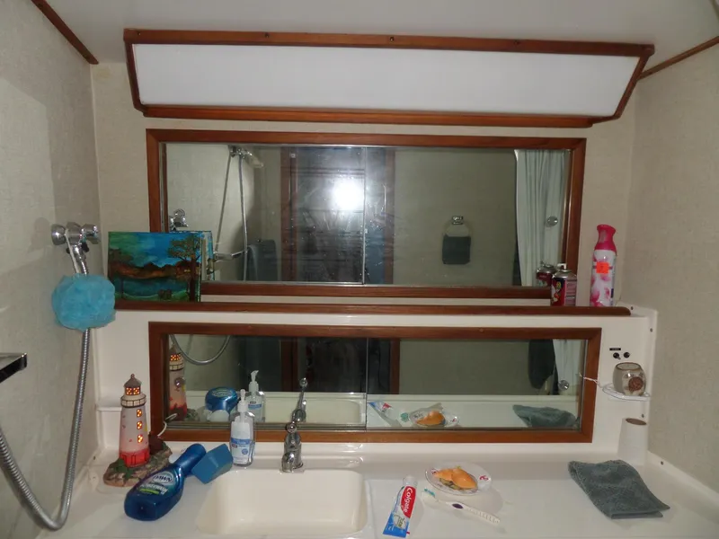 Slide: The Image of 1978 Bertram 42 Flybridge Motor Yacht bathroom with sink, mirror, and toiletries. - 27