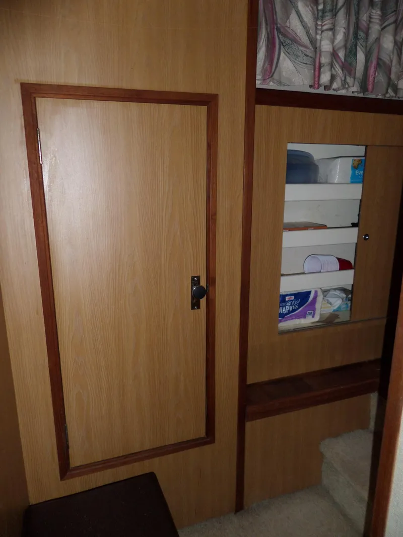 Slide: The Image of 1978 Bertram 42 Flybridge Motor Yacht interior with wooden cabinetry and storage shelves. - 33