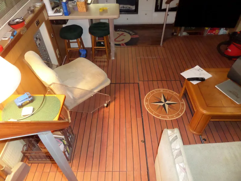 Slide: The Image of Interior of a 1978 Bertram 42 Flybridge Motor Yacht with wooden flooring and seating area. - 37
