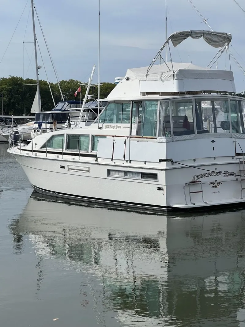 Slide: The Image of 1978 Bertram 42 Flybridge Motor Yacht docked in a marina, reflecting on calm water. - 6