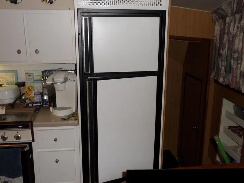 Slide: The Image of 1978 Bertram 42 Flybridge Motor Yacht kitchen with white refrigerator and cabinetry. - 7