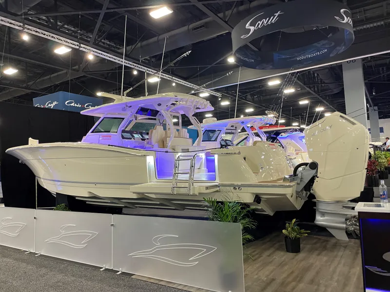 Slide: The Image of 2025 Scout 400 LXF luxury boat displayed at an indoor boat show. - 0