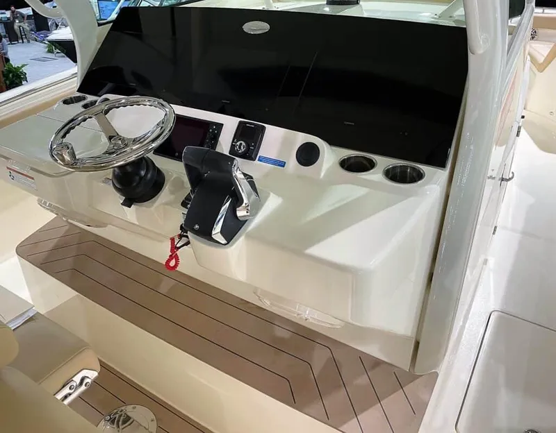 Slide: The Image of 2025 Scout 400 LXF boat helm with steering wheel and control panel. - 1
