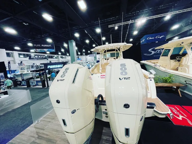 Slide: The Image of 2025 Scout 400 LXF boat with twin 600 V12 engines at a boat show. - 2