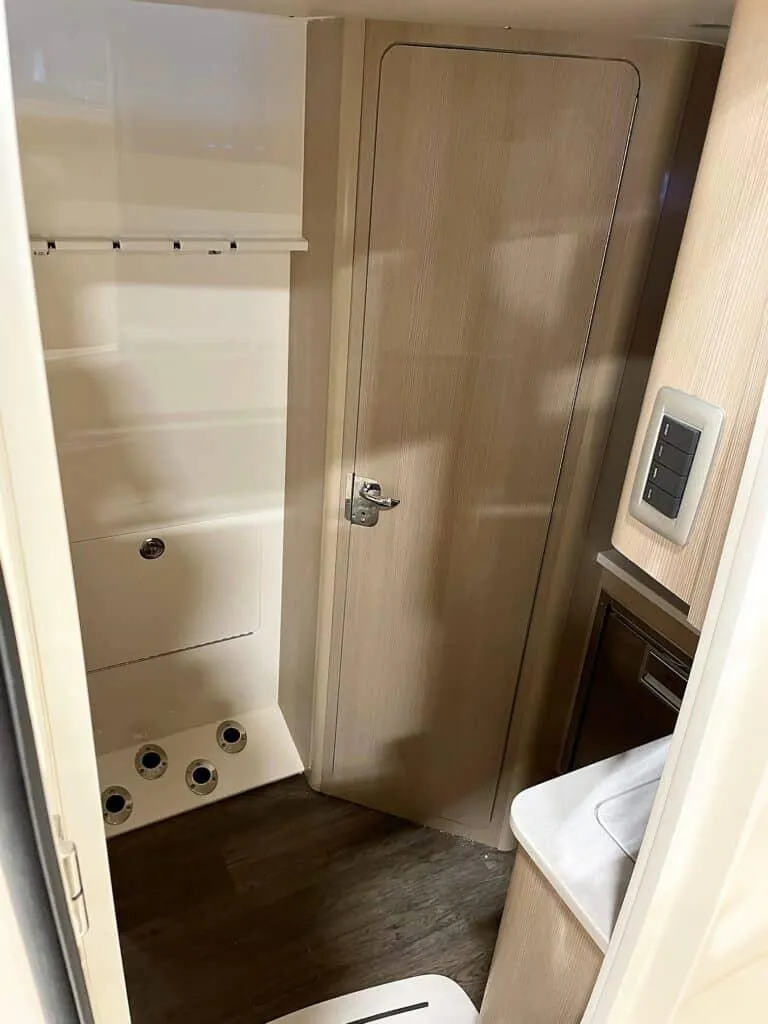 Slide: The Image of 2025 Scout 400 LXF boat interior cabin with wooden door and modern fixtures. - 23