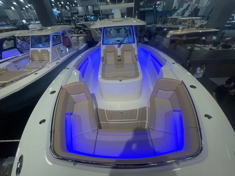 Slide: The Image of 2025 Scout 400 LXF luxury boat with blue LED lighting at a boat show. - 4