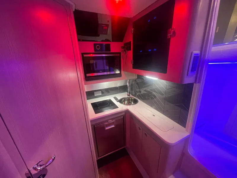 Slide: The Image of Modern kitchen area in 2025 Scout 400 LXF boat with red and blue ambient lighting. - 9
