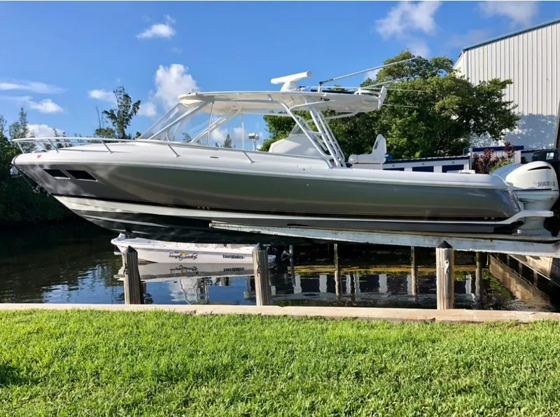The Image of 2015 Intrepid 375 Walkaround boat docked on a lift by the water. - 0