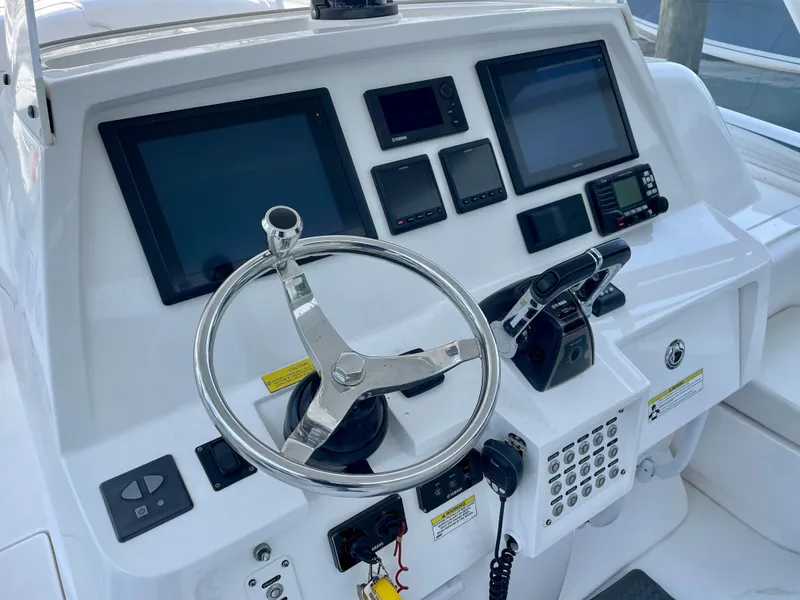 Slide: The Image of Control panel of a 2015 Intrepid 375 Walkaround boat with steering wheel and navigation screens. - 13