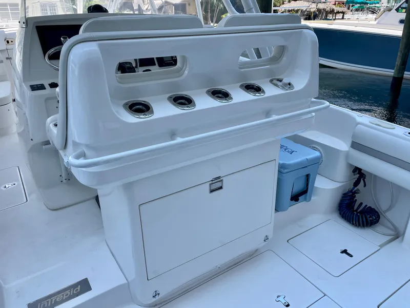 Slide: The Image of 2015 Intrepid 375 Walkaround boat interior with rod holders and storage compartments. - 15