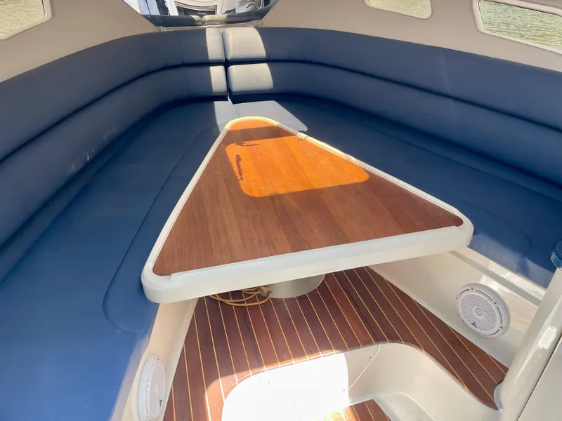 Slide: The Image of 2015 Intrepid 375 Walkaround cabin interior with blue seating and wooden table. - 21