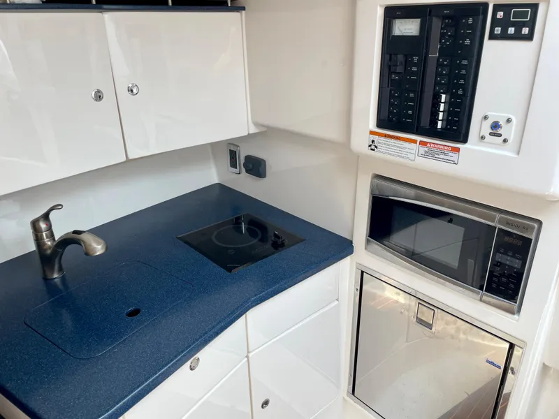 Slide: The Image of 2015 Intrepid 375 Walkaround kitchen area with sink, stove, microwave, and control panel. - 22