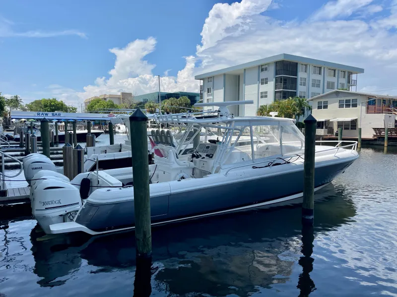 Slide: The Image of 2015 Intrepid 375 Walkaround boat docked at a marina with clear skies. - 27