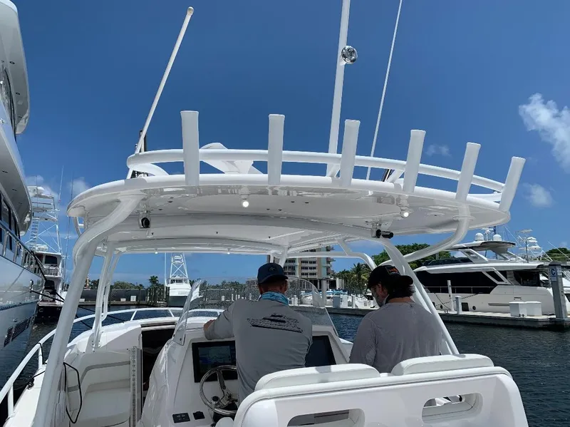 Slide: The Image of 2015 Intrepid 375 Walkaround boat at marina, two people at helm, clear blue sky. - 4
