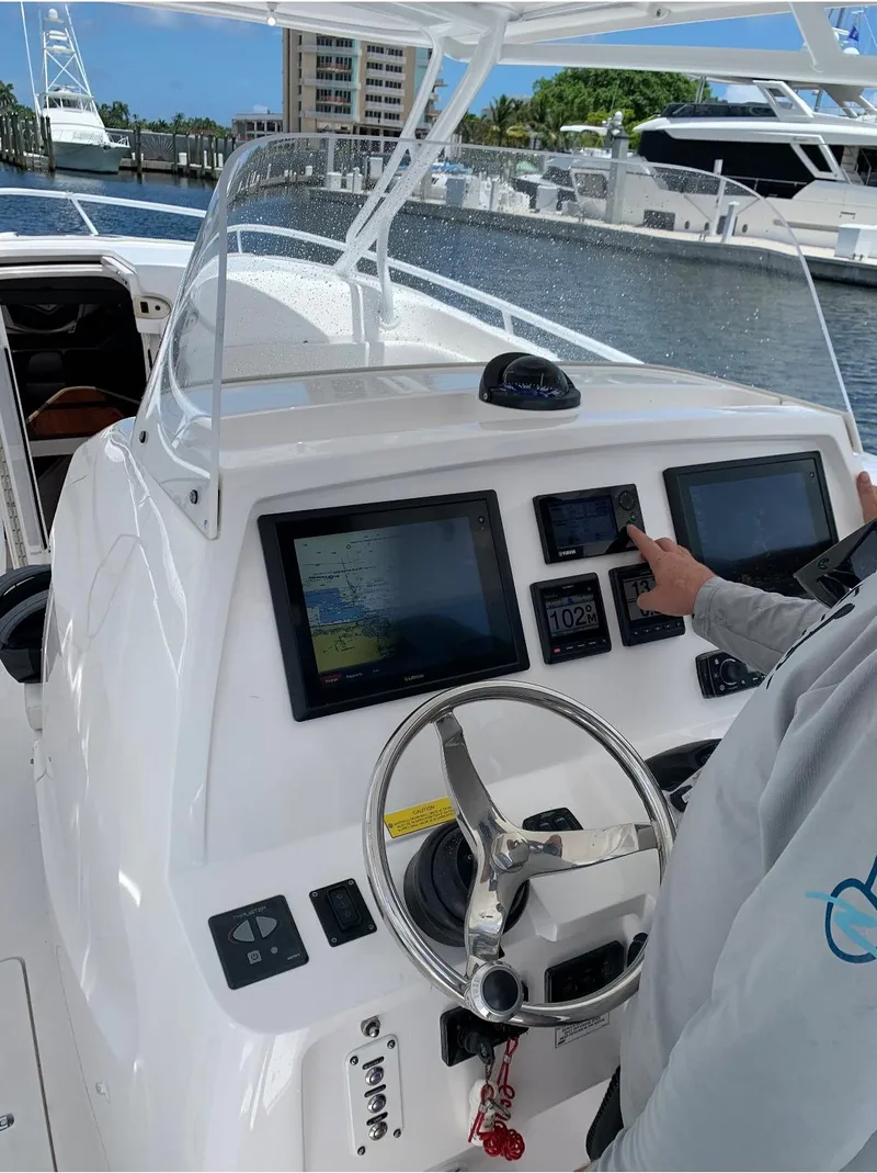 Slide: The Image of 2015 Intrepid 375 Walkaround boat dashboard with navigation screens and steering wheel. - 7