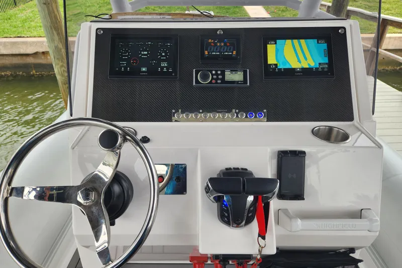 Slide: The Image of 2023 Highfield Sport 900 boat dashboard with steering wheel and navigation displays. - 12