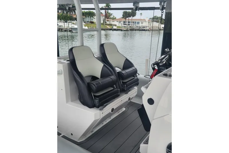 Slide: The Image of 2023 Highfield Sport 900 boat interior with dual black and white seats. - 7