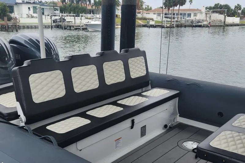 Slide: The Image of 2023 Highfield Sport 900 boat interior with cushioned seating by the water. - 8