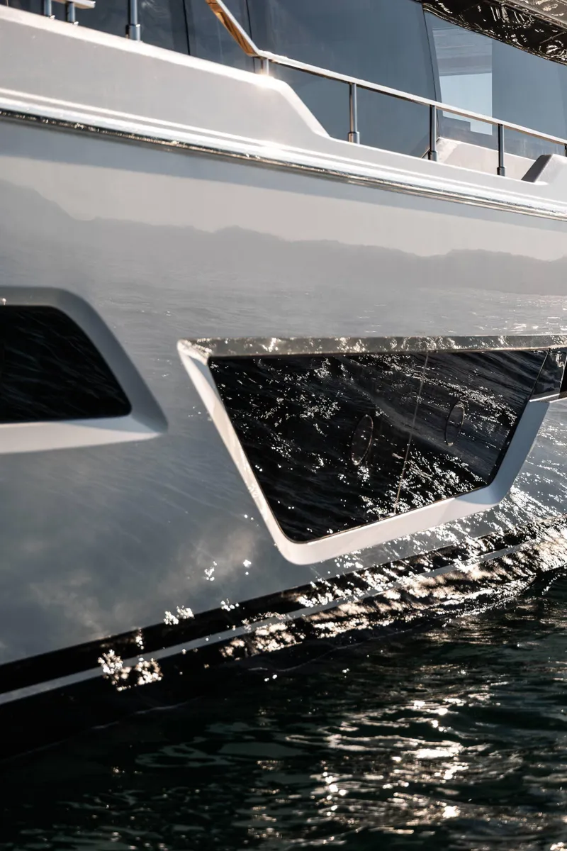 Slide: The Image of Close-up of 2024 Ferretti Yachts 780 exterior reflecting sunlight on water. - 20
