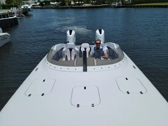 Slide: The Image of 2022 Doug Wright 32 Pleasure Cat boat on water with driver. - 2