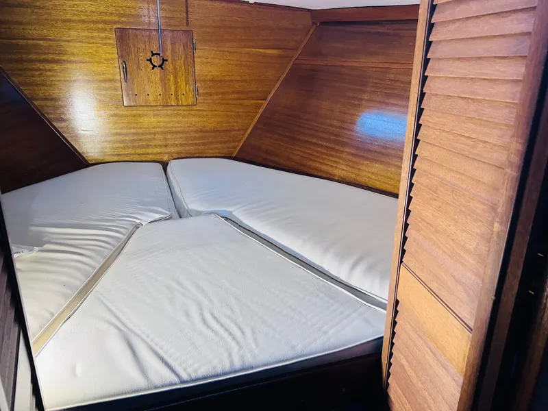 Slide: The Image of 1962 Chris-Craft Roamer cabin interior with wooden walls and white bedding. - 10