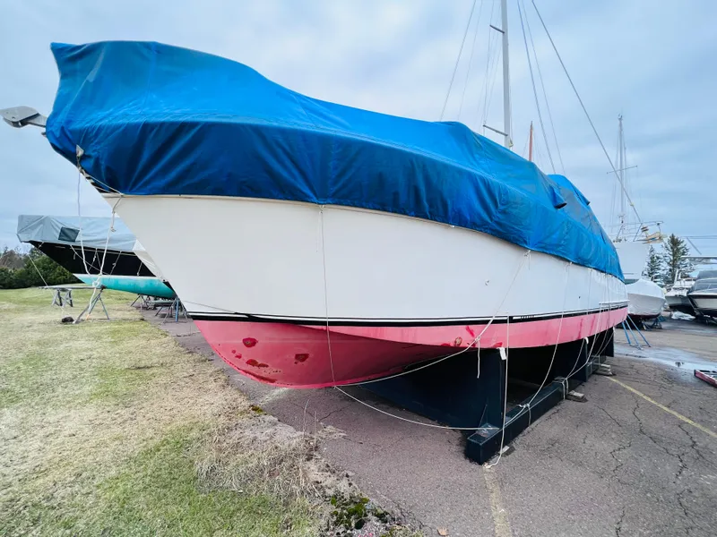 Slide: The Image of 1962 Chris-Craft Roamer boat covered with blue tarp, docked on land. - 14