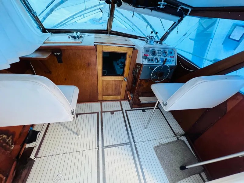 Slide: The Image of 1962 Chris-Craft Roamer cockpit with vintage controls, wooden paneling, and white seating. - 6