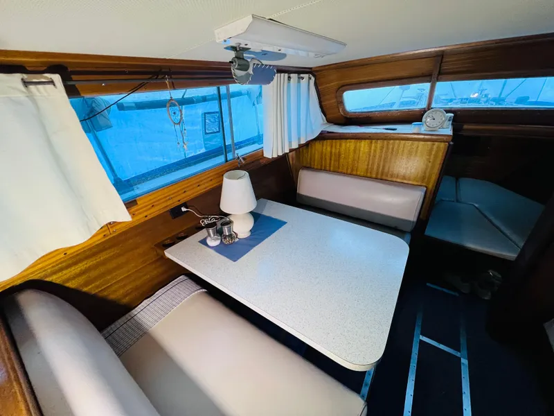 Slide: The Image of 1962 Chris-Craft Roamer interior with dining area, wooden paneling, and nautical decor. - 9