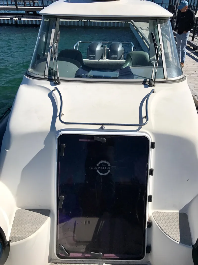 Slide: The Image of 2003 Protector Targa 28 boat docked at a marina, featuring a sleek cabin design. - 15