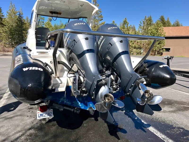 Slide: The Image of 2003 Protector Targa 28 boat with dual outboard motors in a parking lot. - 27