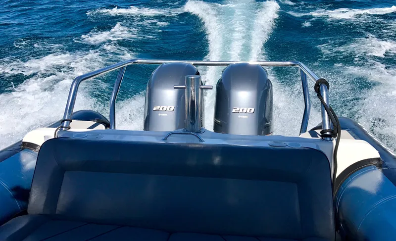 Slide: The Image of 2003 Protector Targa 28 boat with dual 200 horsepower engines cruising on open water. - 8