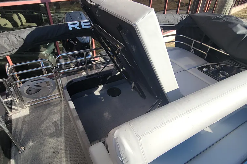 Slide: The Image of 2023 Regency 230 LE3 Sport boat with open storage compartment and seating area. - 6