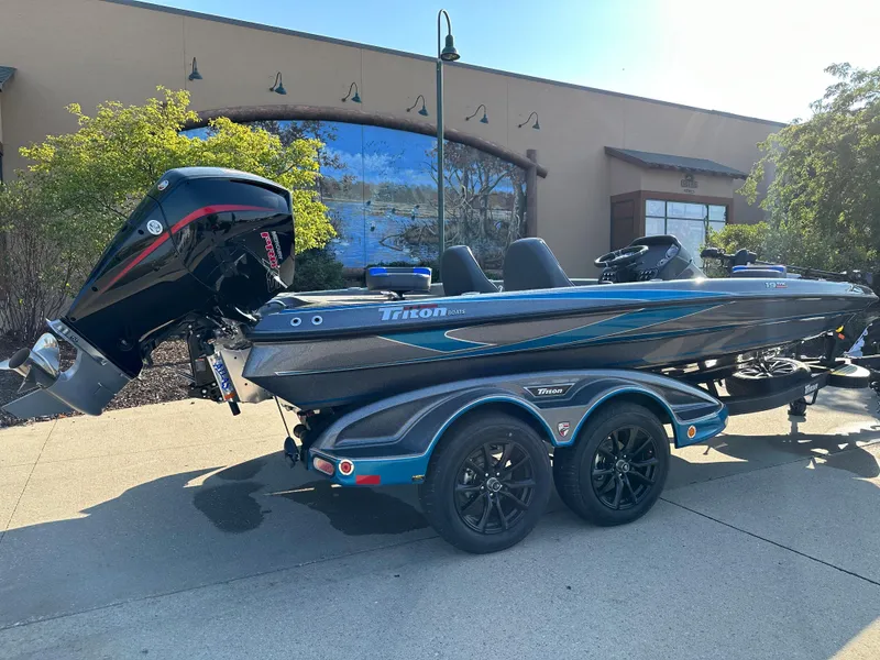 Slide: The Image of 2023 Triton 19 TrX boat on trailer, parked outdoors, side view. - 2