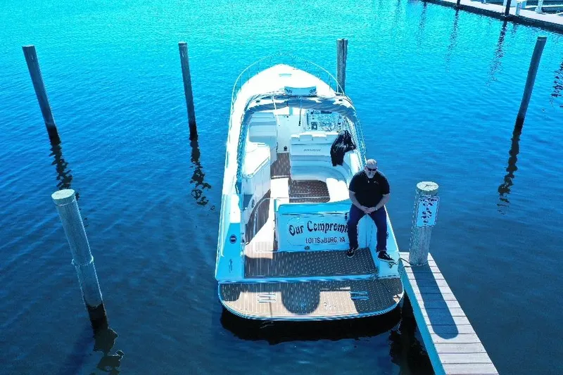 Slide: The Image of 2007 Fountain 38 Express Cruiser docked on calm water, person seated on stern. - 20