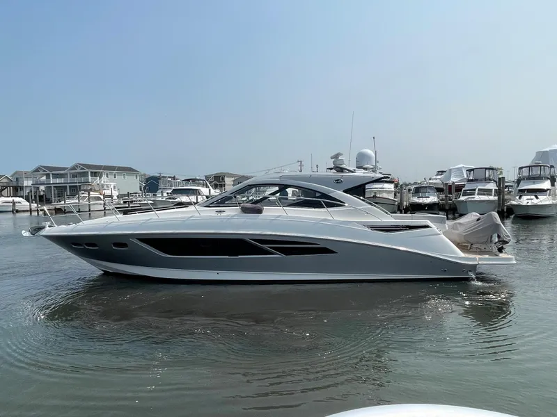 Slide: The Image of A sleek 2018 Sea Ray Sundancer 510 is docked in a marina, surrounded by other boats. - 27