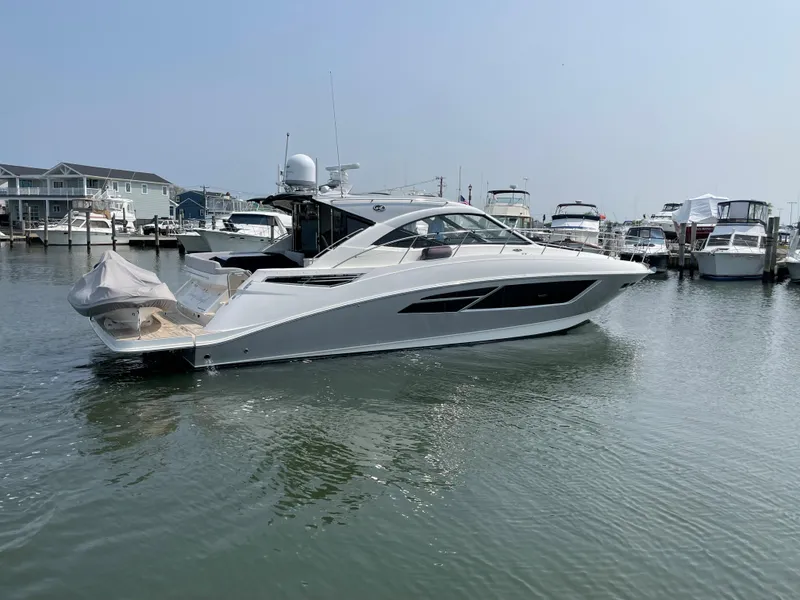 Slide: The Image of A 2018 Sea Ray Sundancer 510 is in the water, surrounded by other boats in the marina. - 7