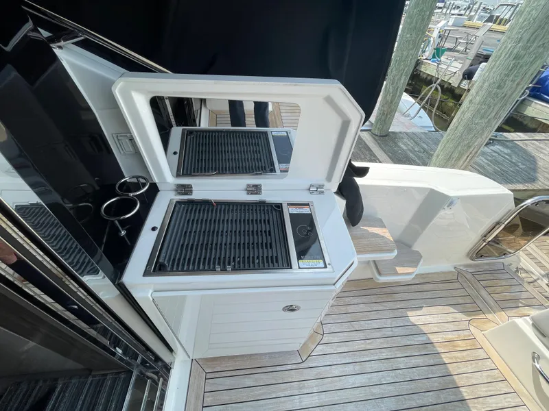 Slide: The Image of The 2018 Sea Ray Sundancer 510 features an outdoor kitchen with a grill and sink on the deck. - 44