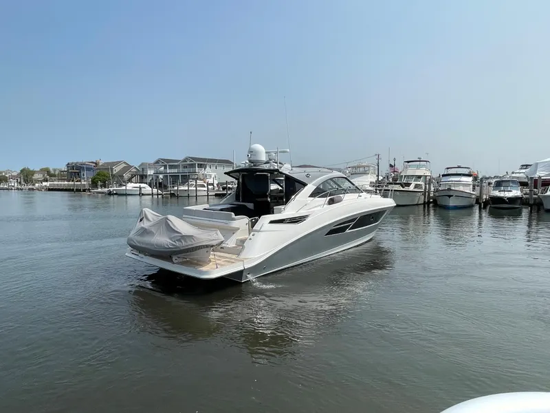 Slide: The Image of A 2018 Sea Ray Sundancer 510 is in the water, surrounded by other boats in the marina. - 6