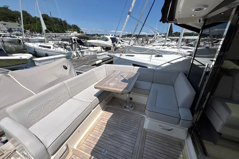 Slide: The Image of Luxurious 2018 Sea Ray Sundancer 510 yacht deck with seating and table, docked at marina. - 94