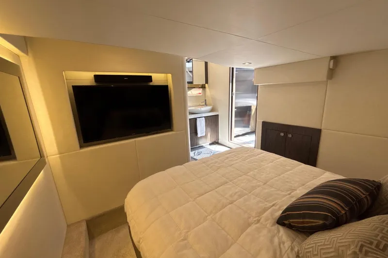 Slide: The Image of Luxurious 2018 Sea Ray Sundancer 510 cabin with TV, bed, and ensuite bathroom. - 139