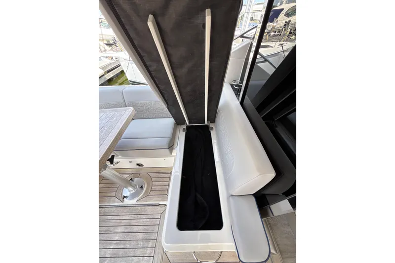 Slide: The Image of 2018 Sea Ray Sundancer 510 yacht interior with open storage compartment and seating area. - 148