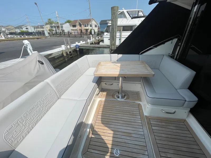 Slide: The Image of The 2018 Sea Ray Sundancer 510 features a spacious seating area with a wooden table on the deck. - 41