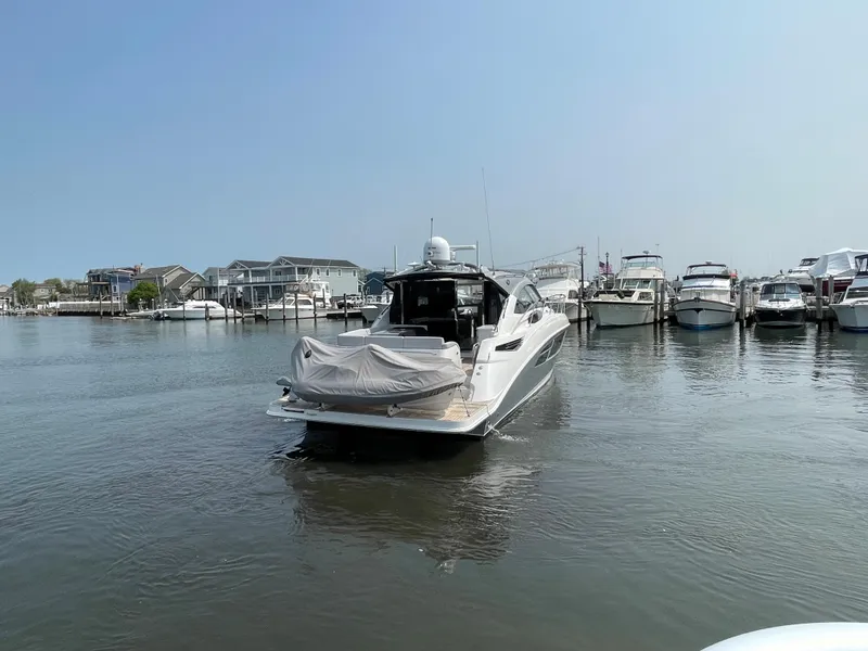 Slide: The Image of A 2018 Sea Ray Sundancer 510 is in the water, surrounded by other boats in the marina. - 36