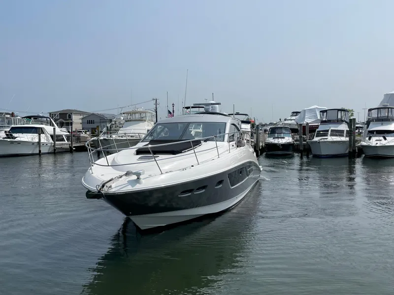 Slide: The Image of A 2018 Sea Ray Sundancer 510 is in the water, surrounded by other boats in the marina. - 20