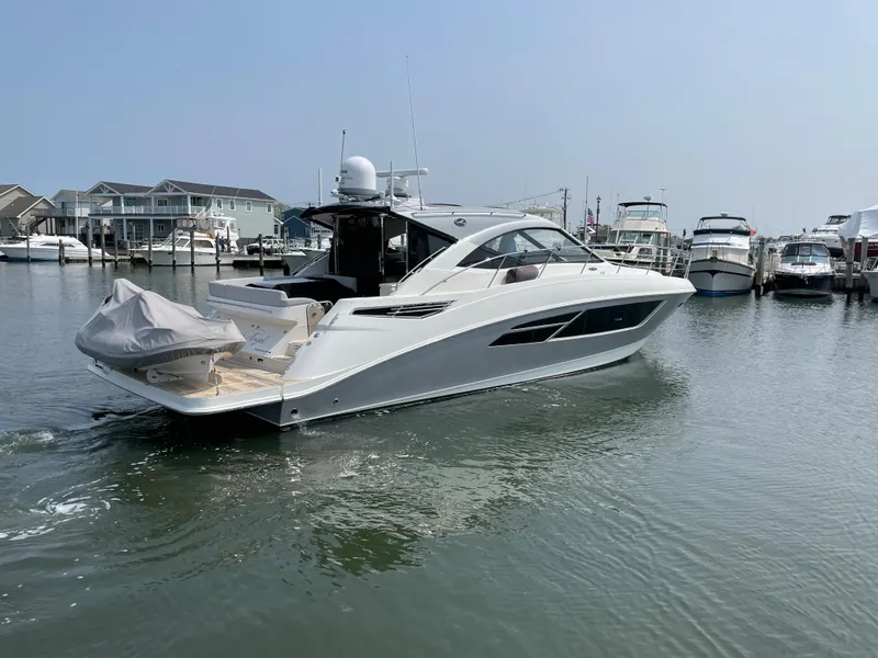 Slide: The Image of A 2018 Sea Ray Sundancer 510 is in the water at a marina, surrounded by other boats. - 5